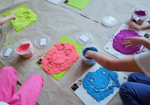 dzieci wykonujące pracę plastyczną - zabawa kolorami